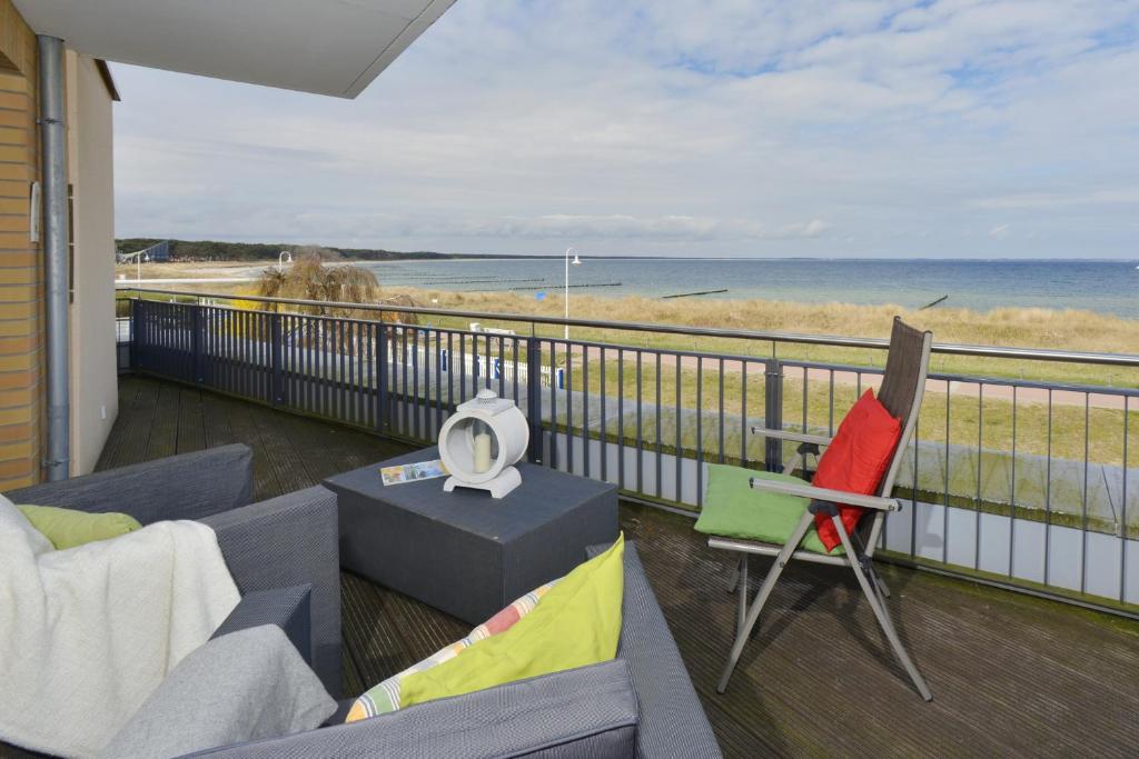 einen Balkon mit Sofa und Stuhl und Strand in der Unterkunft Ferienwohnung Traumstrand in Glowe