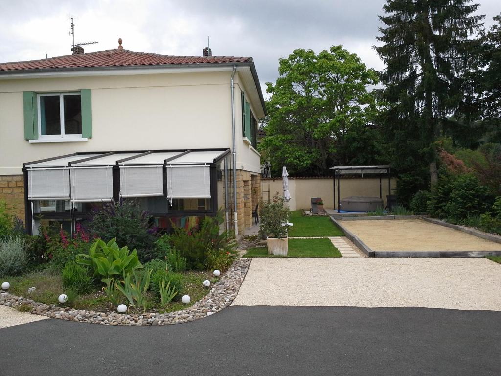 une maison avec un auvent à côté d'une cour dans l'établissement Le Gros Chene, à Sarlat-la-Canéda