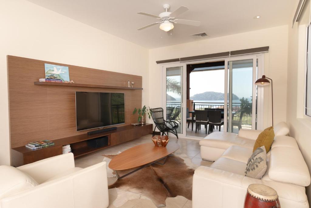 a living room with white furniture and a flat screen tv at CR Luxury Altavista 2B 3 Bdrm in La Mona