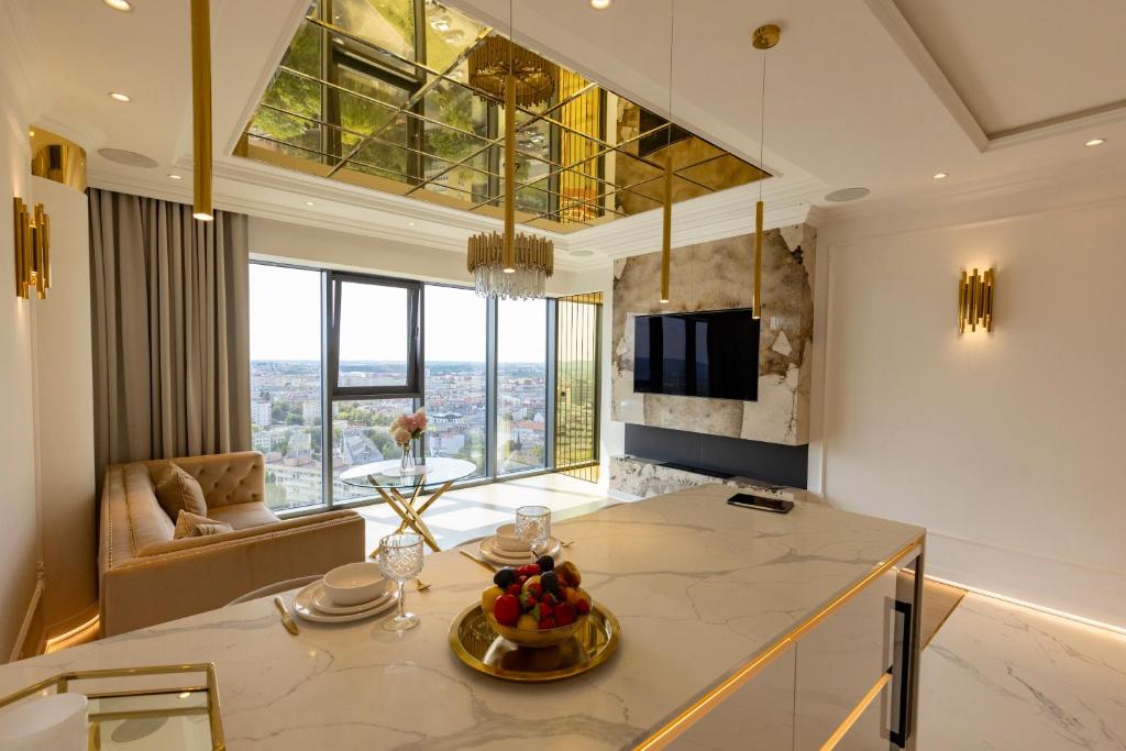 a kitchen with a table with a bowl of fruit on it at HANZA TOWER GOLD 19th Floor in Szczecin
