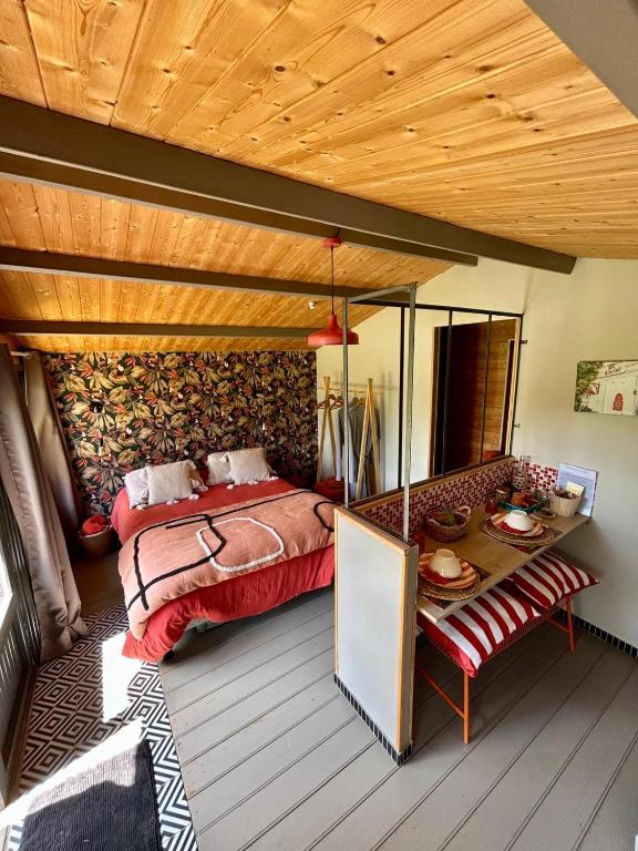 une chambre avec un lit et un plafond en bois dans l'établissement La Cabane du Verger, à Montignac
