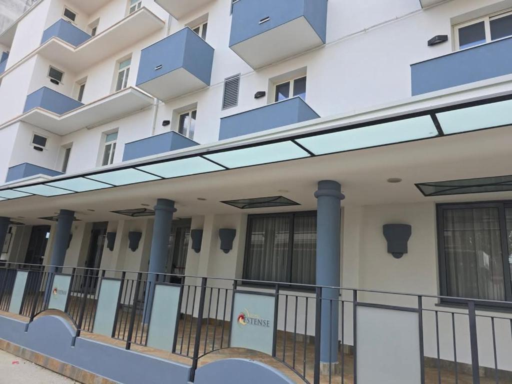 an external view of a building with blue balconies at Hotel Estense in Bellaria-Igea Marina