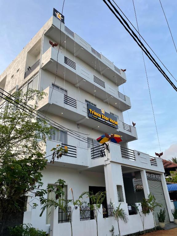 亭可马里Koala Backpackers的一座挂着酒店标志的白色建筑