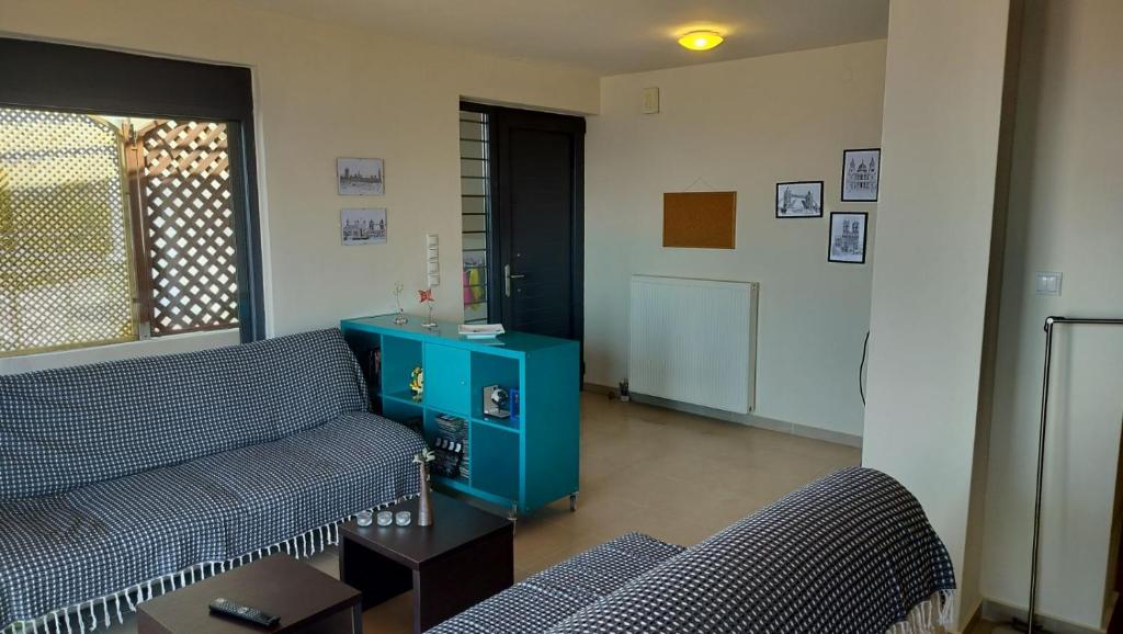 a living room with two couches and a blue cabinet at Casa del Mar in Preveza
