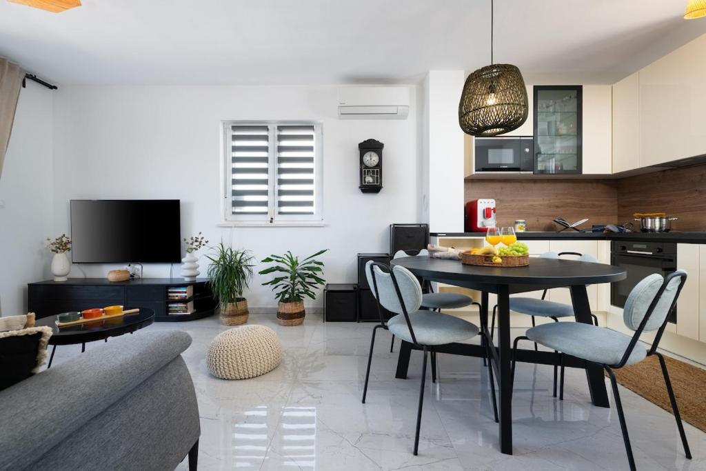 a kitchen and living room with a table and chairs at Apartment Grey in Medulin