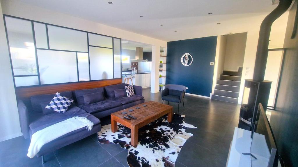 un salon avec un canapé bleu et une table dans l'établissement Exceptional Border Villa, à Village-Neuf
