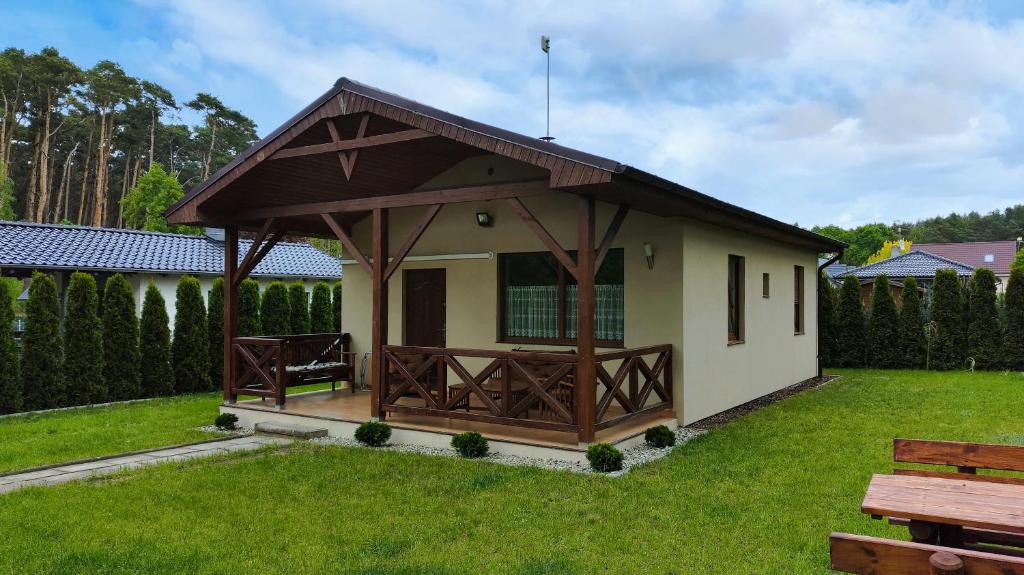 a small building with a gazebo in a yard at Domek letniskowy Pod Topolami in Sieraków