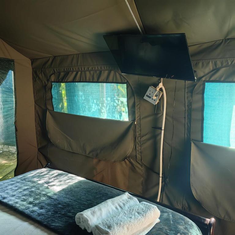 a bed in a tent with a towel on it at Tent On Manor in Durban