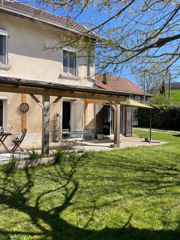 Charmante maison de campagne proche du lac de Paladru في Valencogne: منزل أمامه حديقة