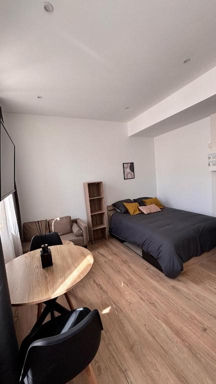 une chambre avec un lit, une table et des chaises dans l'établissement Studio cosy hyper centre, à Agen