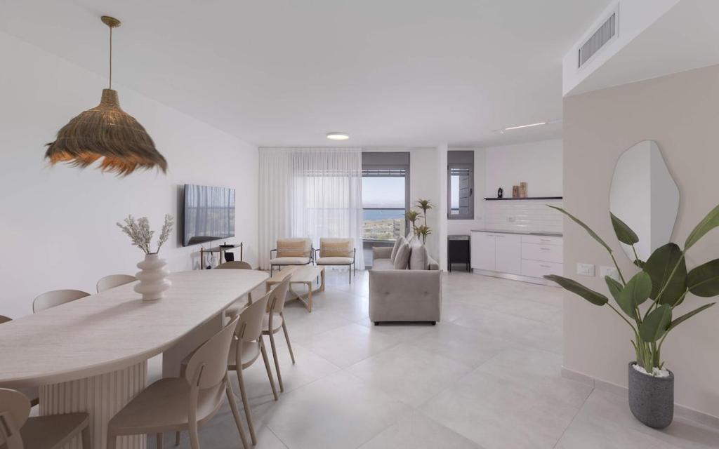 une salle à manger et un salon avec une table et des chaises dans l'établissement נופש משפחתי באילת עם נוף לים האדום, à Eilat