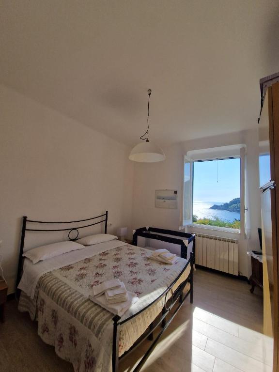 a bedroom with a bed and a large window at Il Paradiso di Adriana in Bonassola