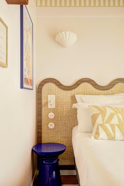 a bedroom with a bed with a purple table next to it at Hôtel Gabriel in Menton