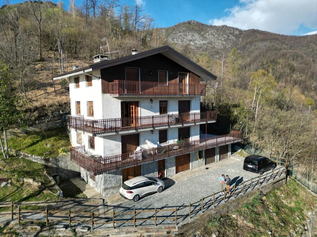 a house with two cars parked in front of it at Gold Cave casa vacanze relax nel bosco appartamenti in Pessinetto