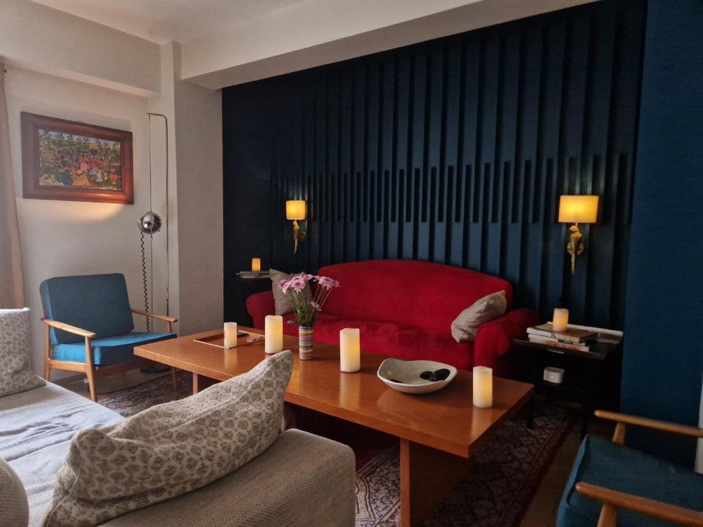 a living room with a red couch and a table at Art Deco Room Condesa Shared Apartment in Mexico City