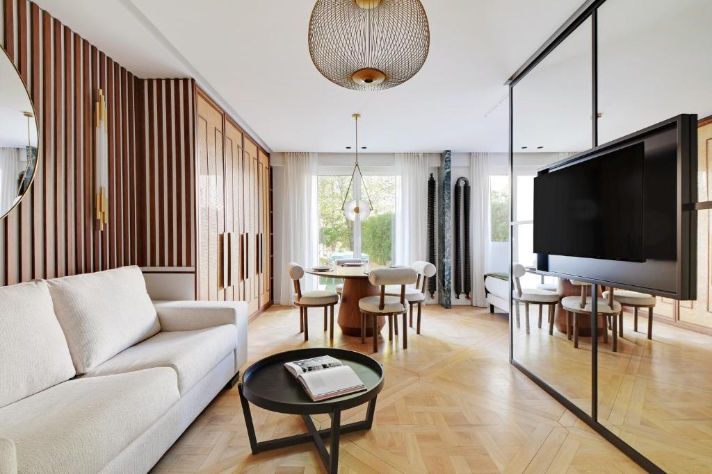 un salon avec un canapé blanc et une télévision dans l'établissement Super studio 4P avec jardin - Neuilly sur Seine, à Neuilly-sur-Seine