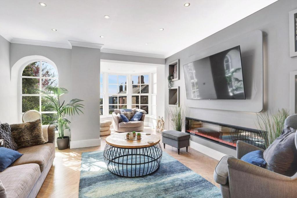 a living room with a couch and a tv at Martineau House - North East Escapes in Tynemouth