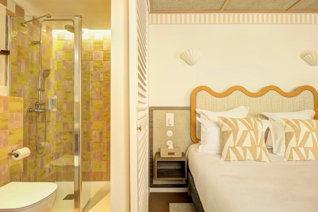 a bedroom with a bed and a shower at Hôtel Gabriel in Menton