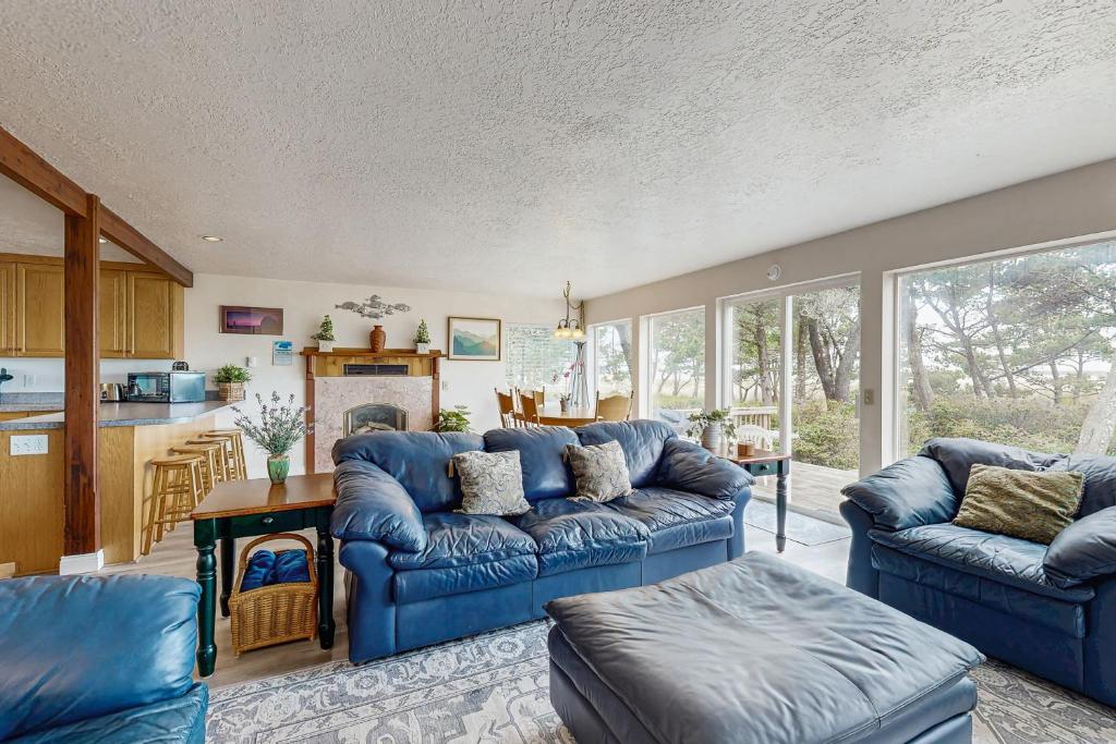a living room with blue couches and a kitchen at Beach Time Getaway in Lincoln City