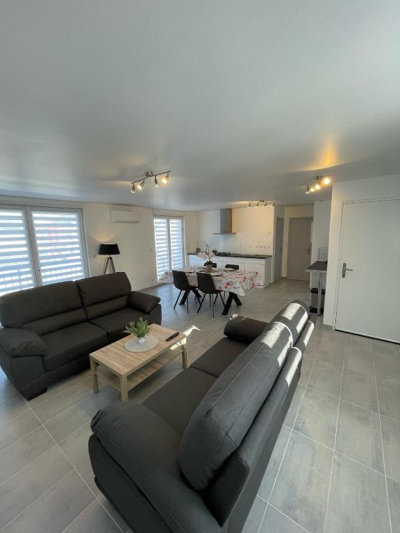 un salon avec un canapé et une table dans l'établissement L'escapade Confort Saint-Quentinoise, à Saint-Quentin