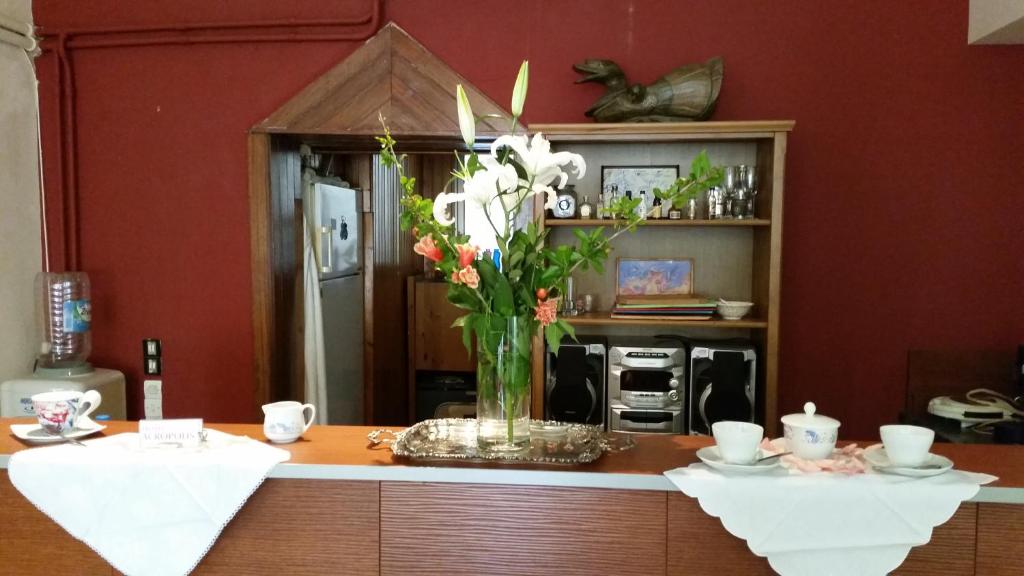 a kitchen with a vase of flowers on a counter at Acropolis Hotel in Korinthos