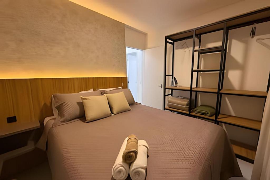 ein Schlafzimmer mit einem Bett mit einem Paar Hausschuhen darauf in der Unterkunft Apartamentos para 5 pessoas com Piscina e Academia no Centro in Curitiba