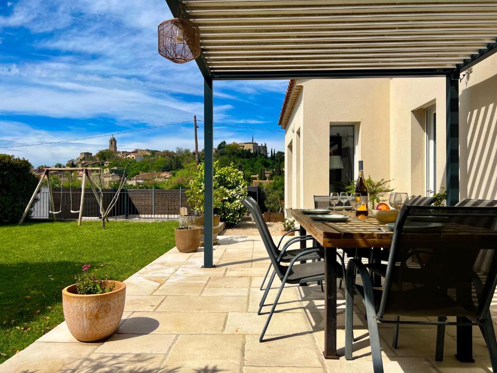 d'une terrasse avec une table et des chaises sous un auvent. dans l'établissement Le temps de vivre, à Mormoiron