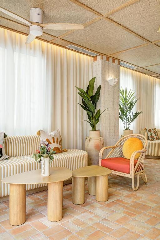 a living room with couches and tables and plants at Hôtel Gabriel in Menton