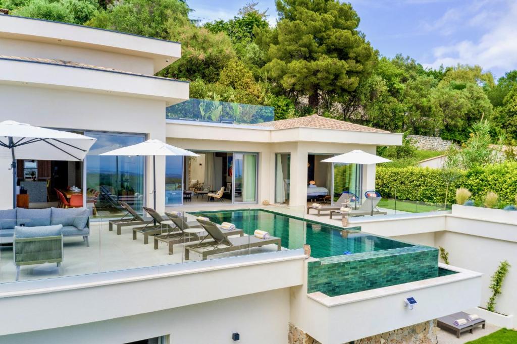 une vue extérieure d'une maison avec piscine dans l'établissement Villa Prestige et Vue Mer, à Tourrettes-sur-Loup