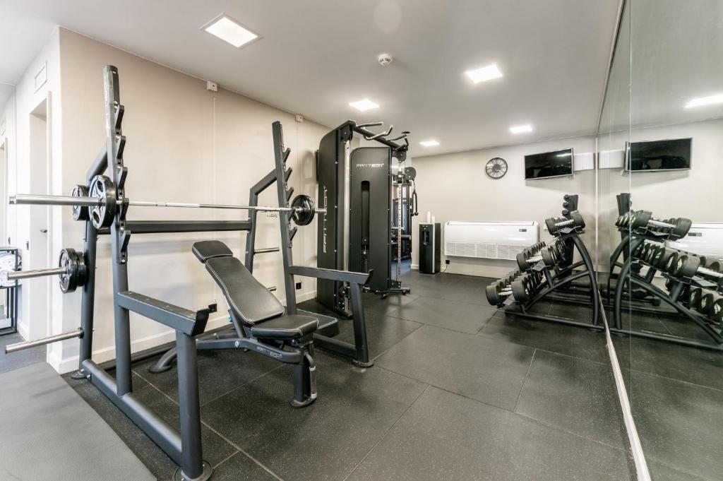 A bright hotel gym with strength equipment and cardio machines.