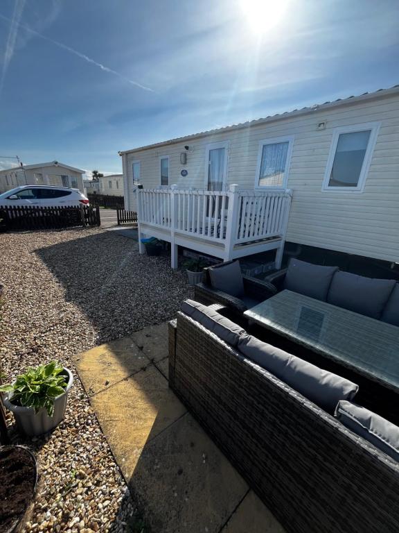 a house with a patio and a couch in a yard at 163 Holiday Resort Unity Brean sands Pet friendly in Berrow