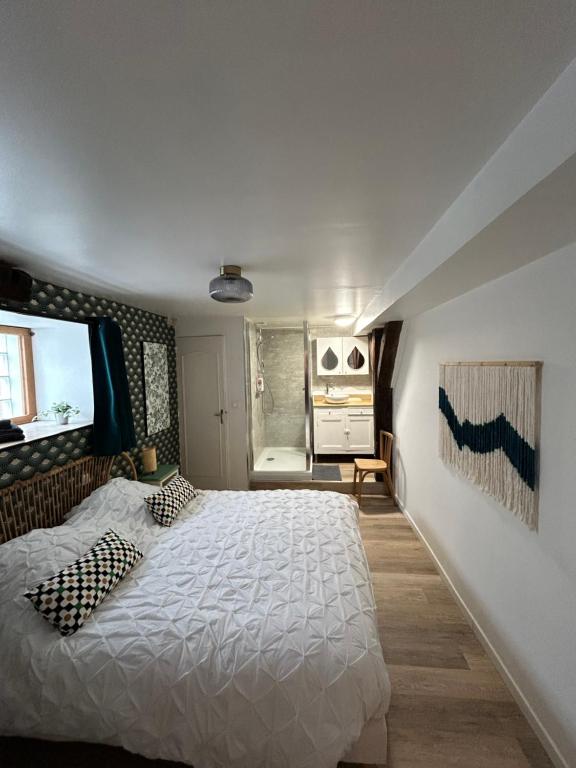 une chambre avec un grand lit blanc et une salle de bain dans l'établissement Appartement cosy en amoureux, à Ménétréol-sous-Sancerre