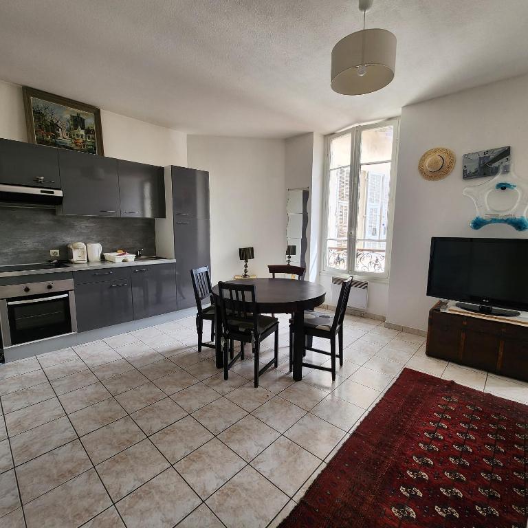une cuisine et une salle à manger avec une table et des chaises dans l'établissement Appartement a deux pas de la Promenade des Anglais, à Nice