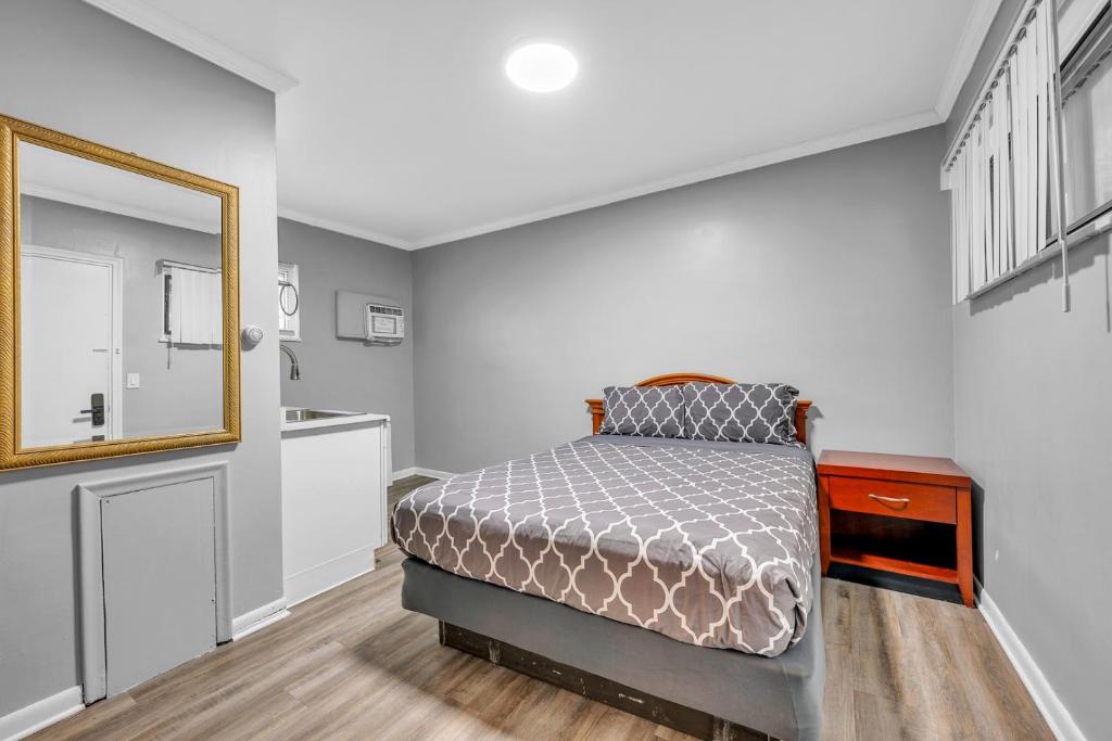 WoodhavenにあるPrivate Stay for 2 • Near Food Fun Spotsのベッドと鏡のある小さな寝室