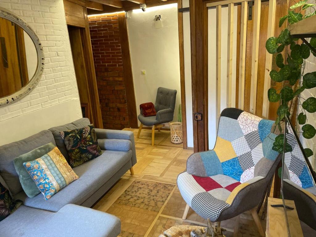salon z kanapą i krzesłem w obiekcie Casita Tanea Montaña y cerca del mar en Cantabria w mieście Quintanilla