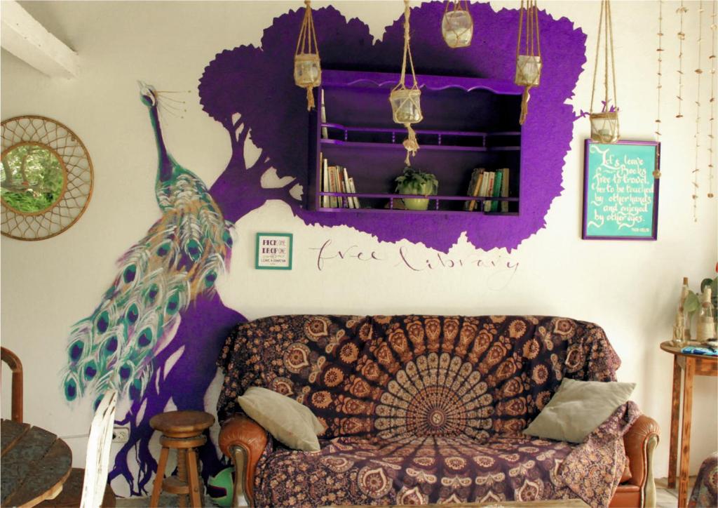 a living room with a peacock painted on the wall at Natural Mystic Hostel in Costa da Caparica