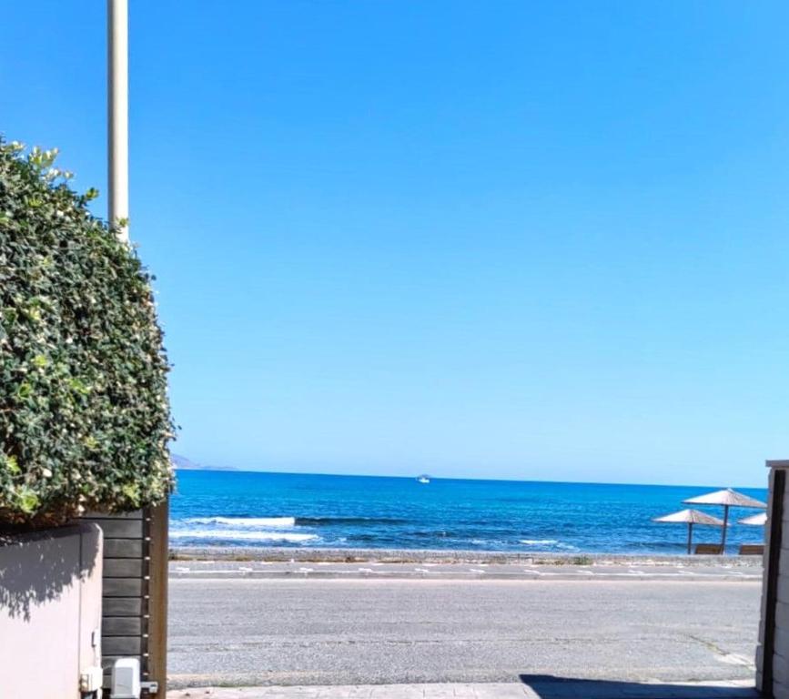 a view of the beach with an umbrella and the ocean at Turquoise Front Sea Apartment in Kokkíni Khánion