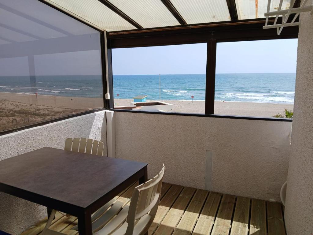 une salle à manger avec une table et une vue sur la plage dans l'établissement Magnifique vue plage joli appartement 5 personnes secteur Allée des Arts, au Barcarès