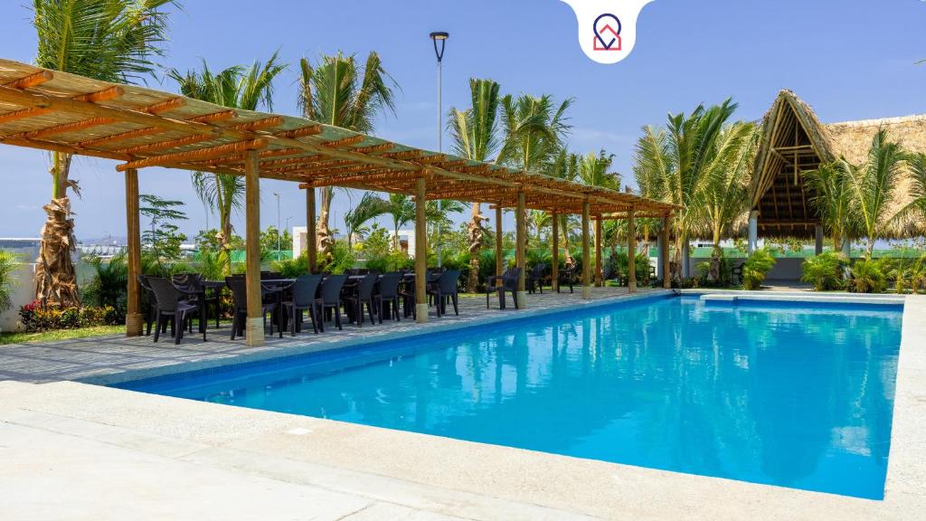 a pool at a resort with a table and chairs at Beautiful Apartment in Dream Acapulco Diamante in Acapulco