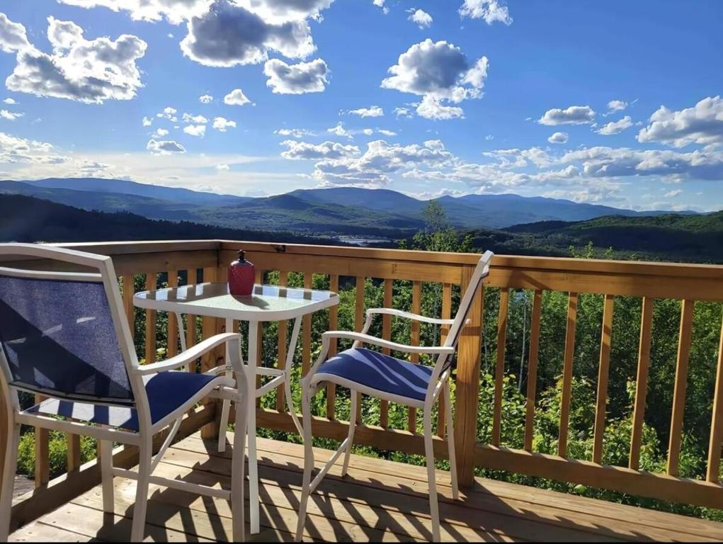 a table and two chairs on a deck with a view at Mountains Getaway in Campton