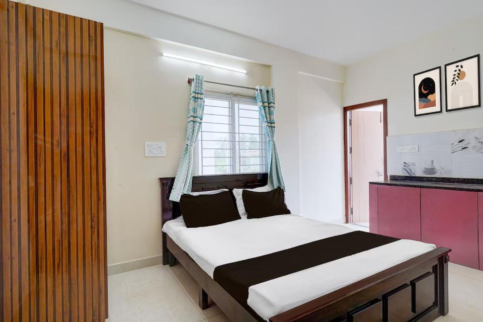 a bedroom with a bed and a large window at Paradise Living in Bangalore