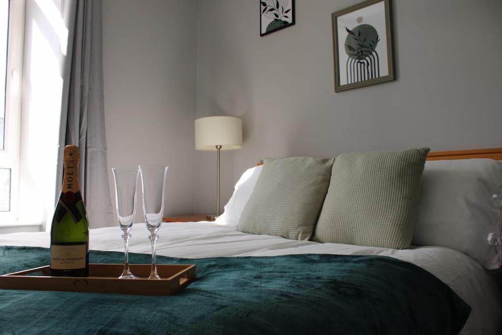 a bed with a bottle of wine and glasses on it at Trendy Apartment in Tralee in Tralee