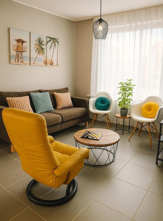 a living room with a yellow chair and a couch at Escape Playero in Breskens