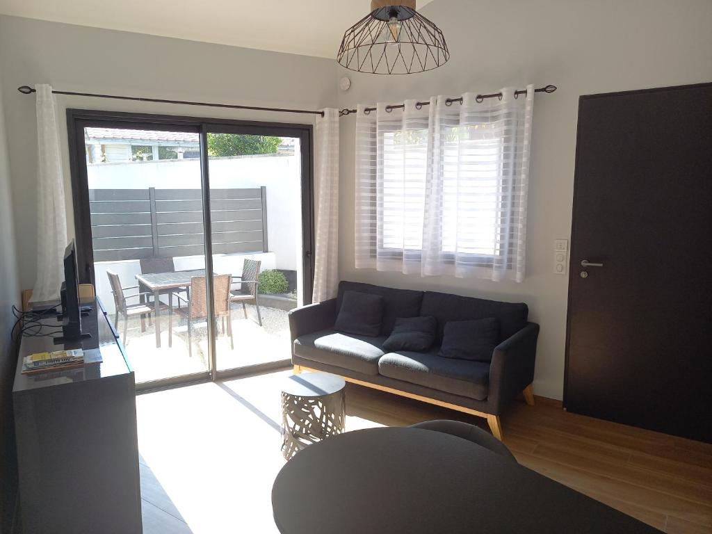 un salon avec un canapé et une table dans l'établissement Appartement T2 proche forêt et plages, à Anglet