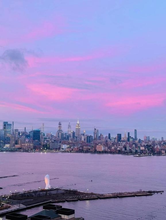 a view of a city from the water at sunset at Cozy City Nest in Jersey City