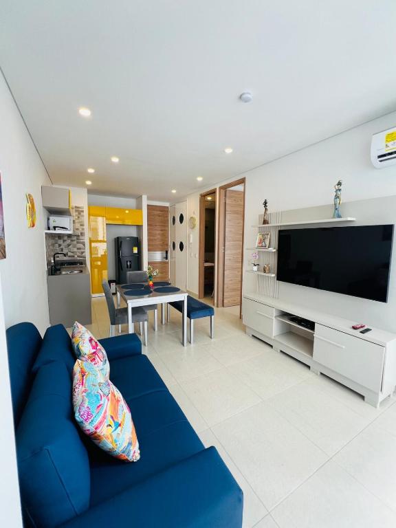 a living room with a blue couch and a tv at Comfortable apartment near the beach in Playa Bello Horizonte