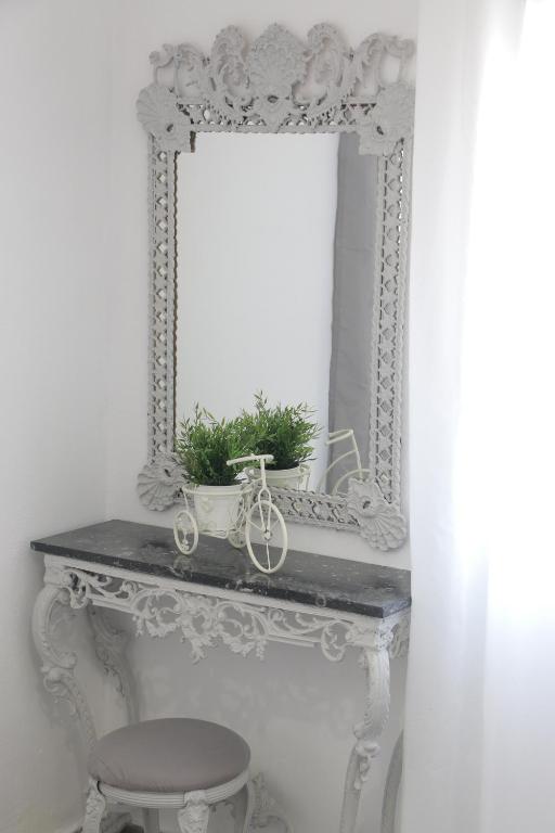 a mirror sitting on top of a table with a stool at Bonatsa House in Agios Georgios