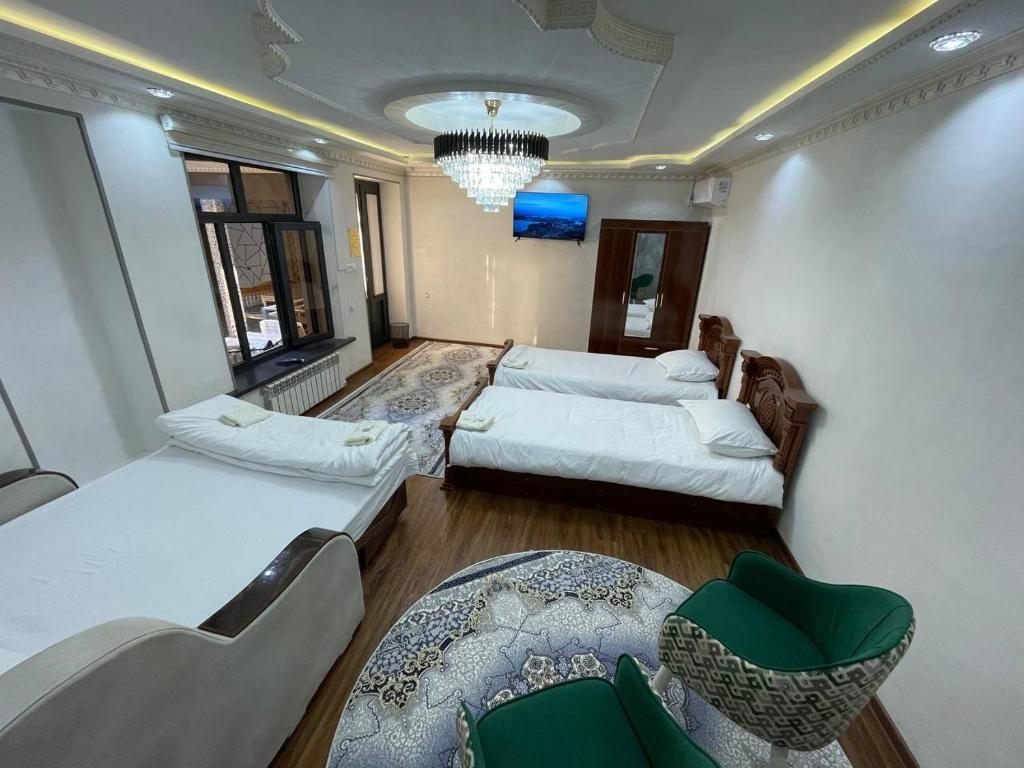 een woonkamer met twee bedden en een bank bij Anoras home in Samarkand