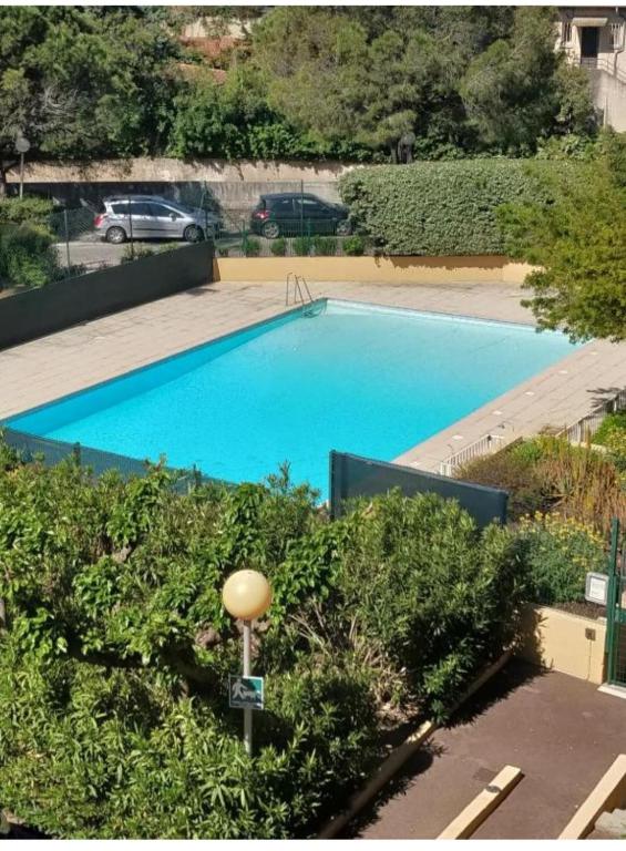une grande piscine bleue dans une cour dans l'établissement Appartement T3 climatisé avec piscine et plages à pied, à Saint-Raphaël