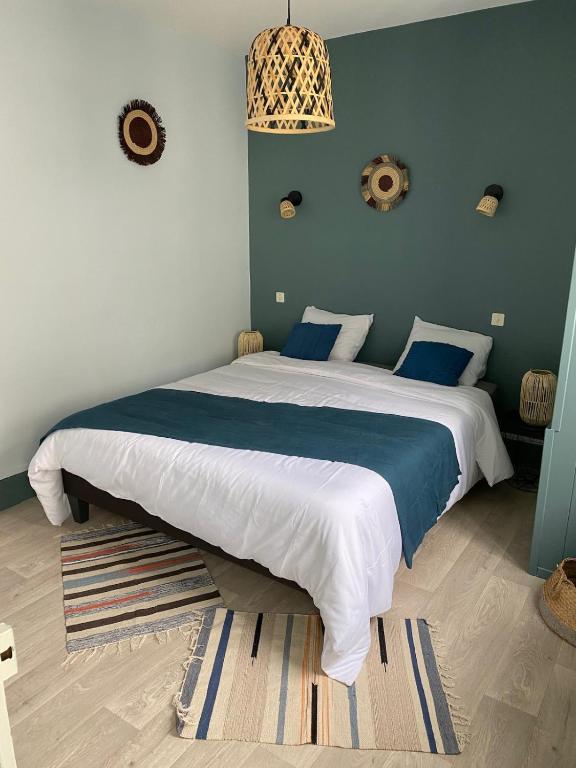 une chambre avec un grand lit avec des draps bleus et blancs dans l'établissement les petits sportifs, à Léré